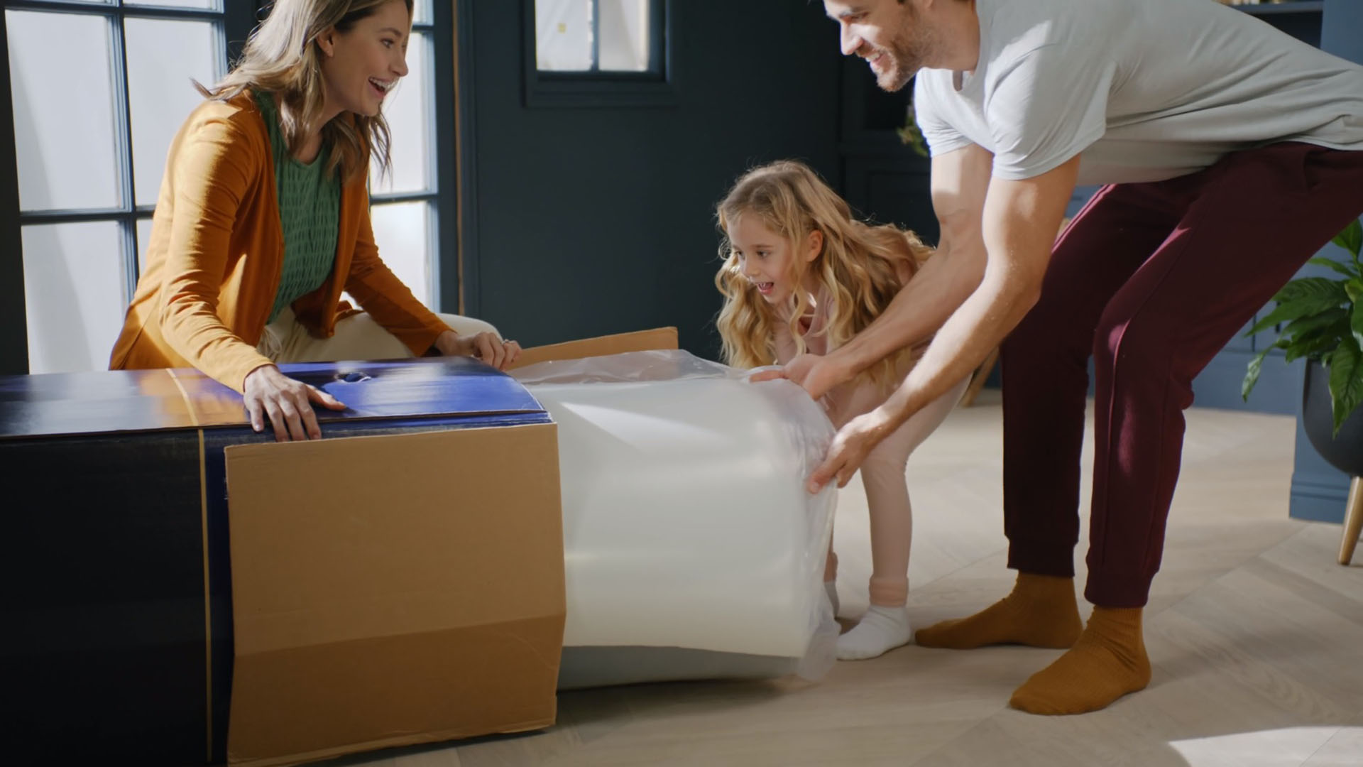 A family unboxing a Dreamcloud mattress in Cedar Rapids, Iowa